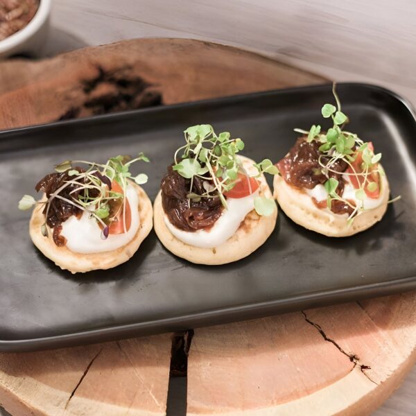 Blinis with red onion confit, crème fraîche & chives (v)